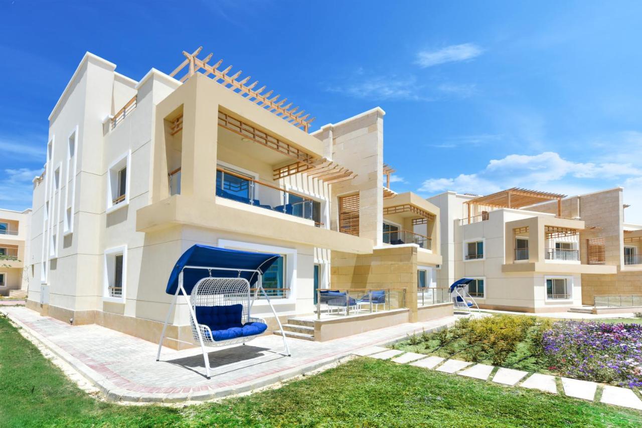 Tolip Resort El Galala Majestic Ajn-Szuhna Kültér fotó The photo displays a modern residential complex featuring two or more white buildings with a contemporary architectural design. Each building has balconies, large windows, and a sunshine-friendly layout that maximizes natural light. In the foreground
